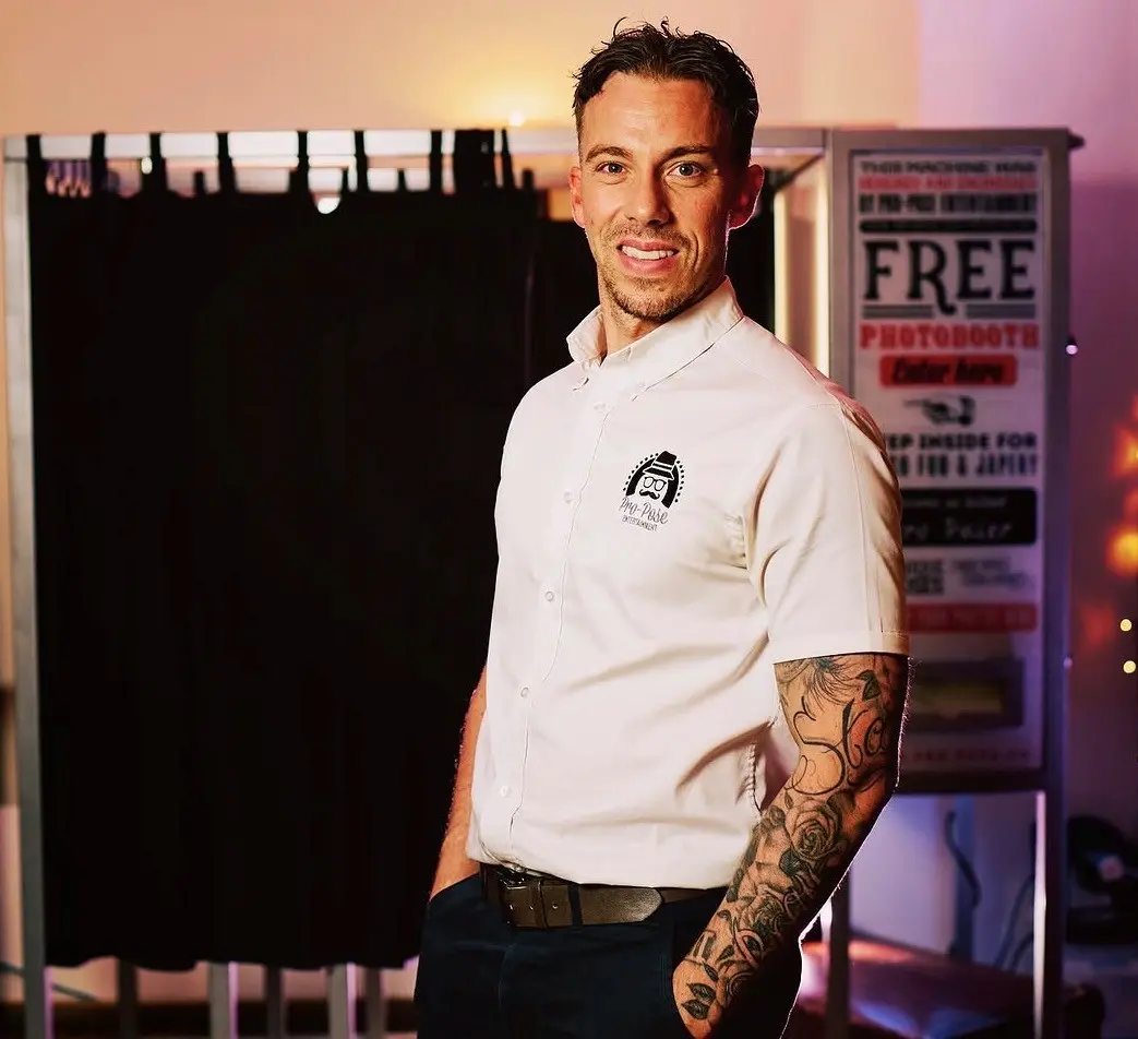 Dan, founder of Pro-Pose Entertainment, standing beside a photo booth